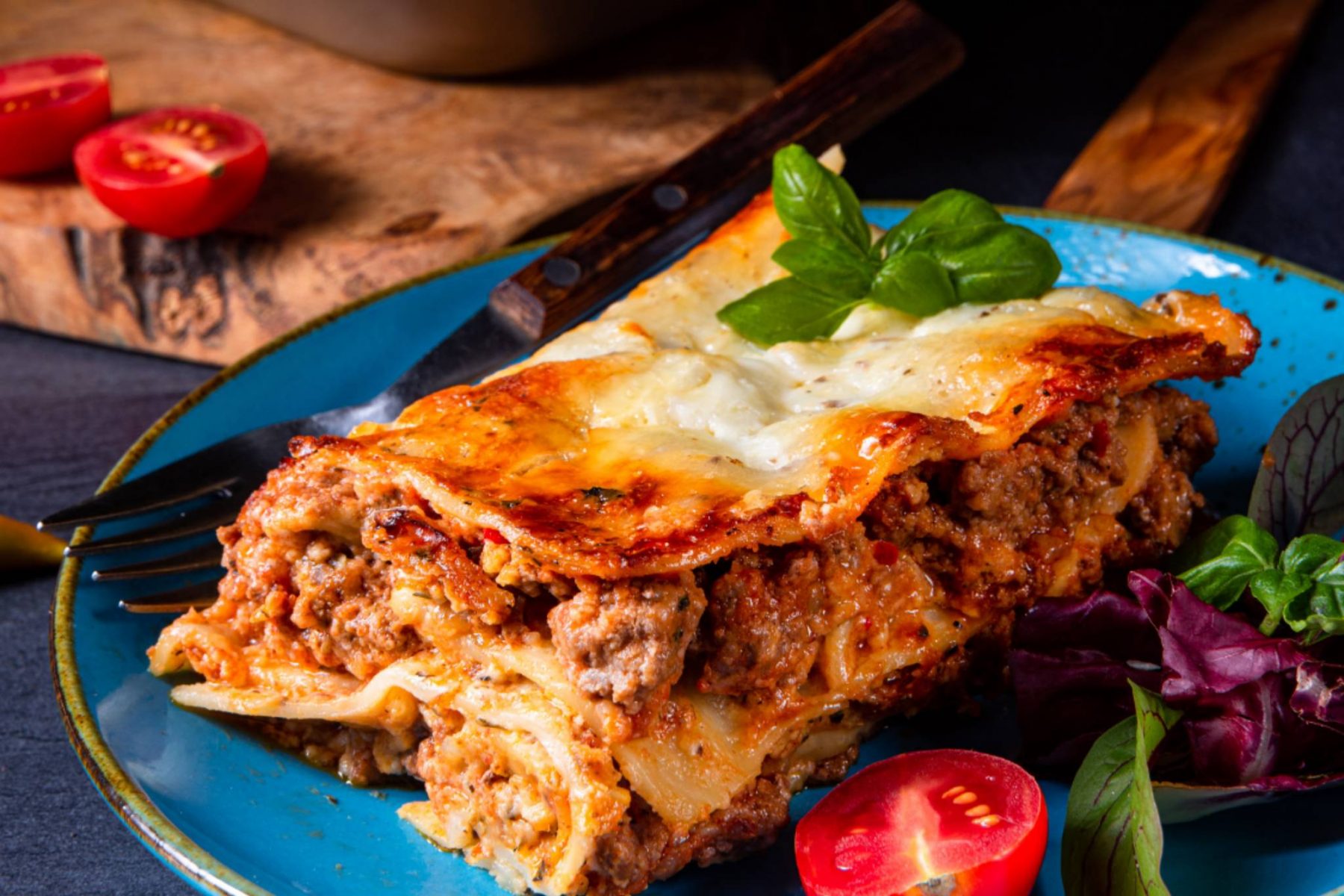 Hearty beef lasagne with melted cheese and rich tomato sauce served on a blue plate