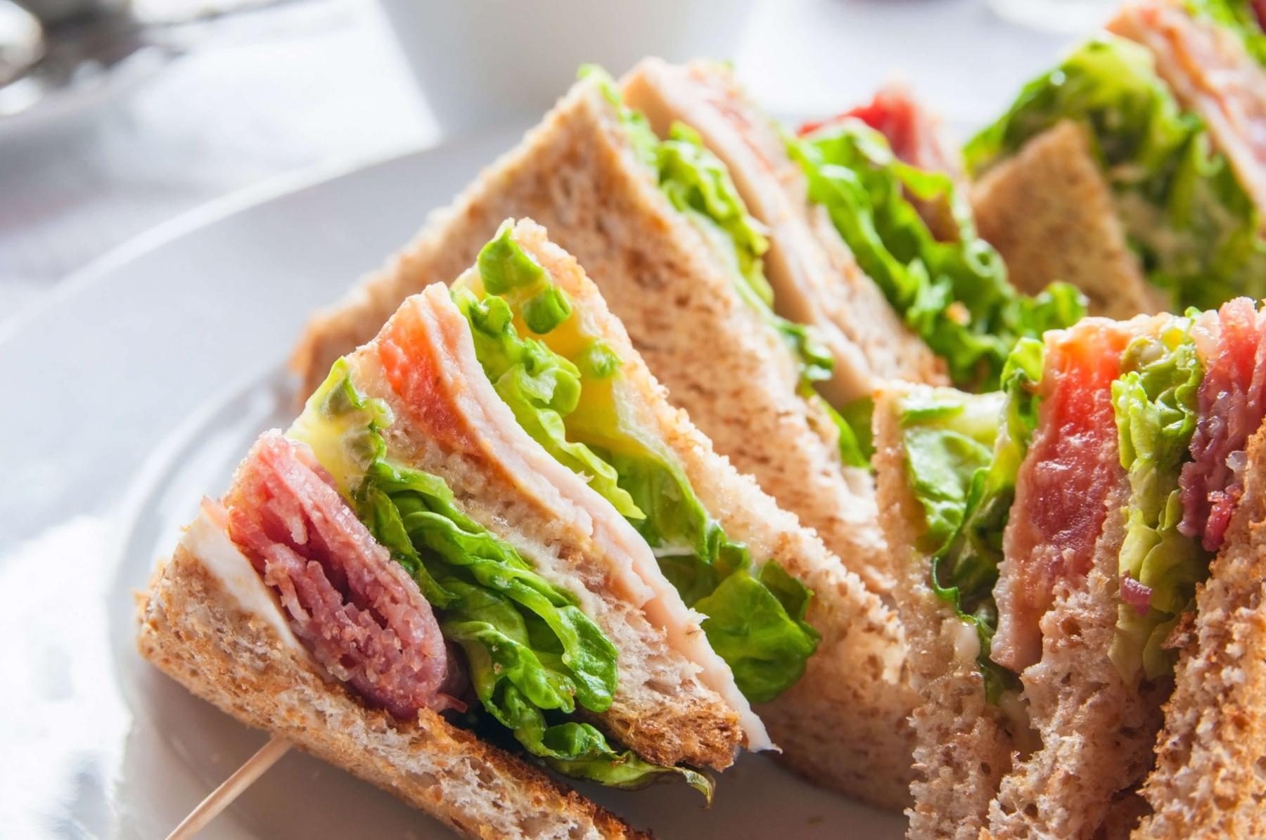 Freshly made club sandwich with chicken, bacon, lettuce and tomato on wholemeal bread