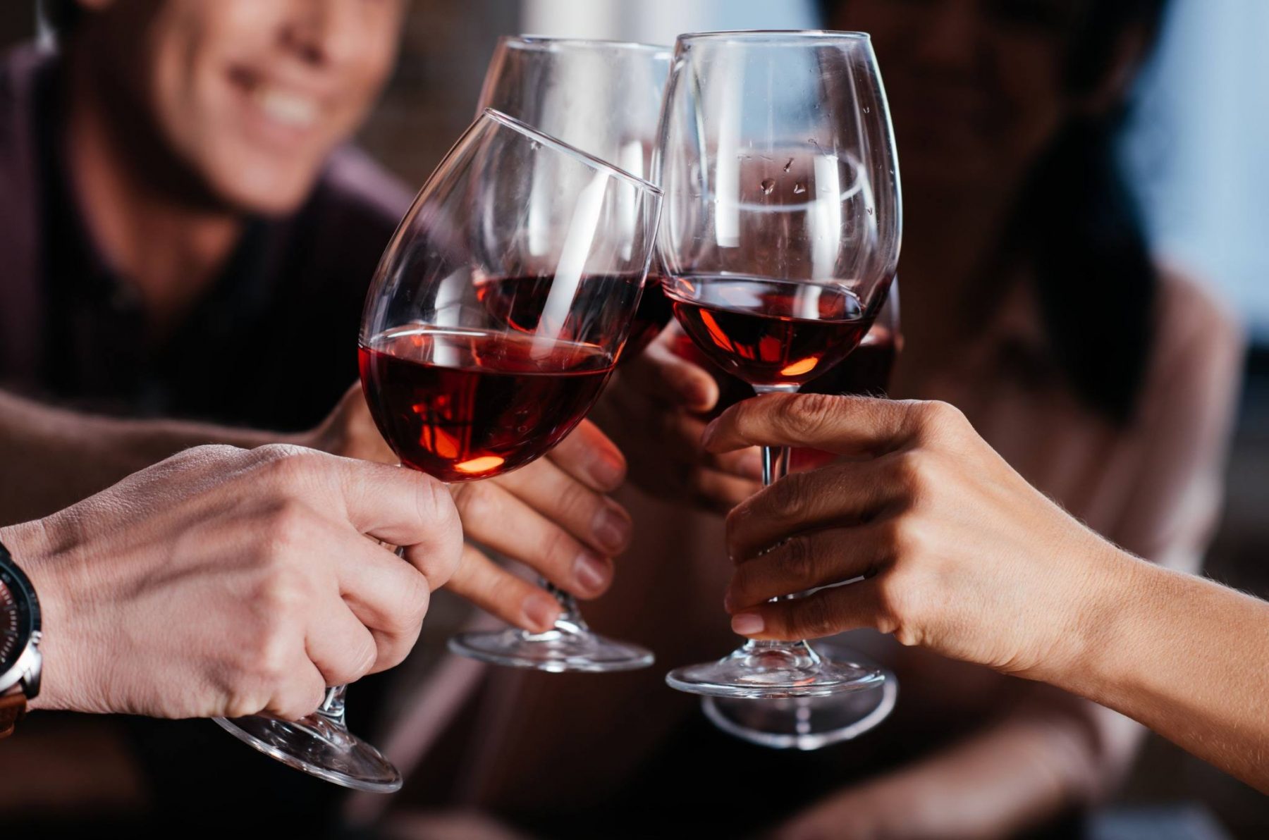 Guests clinking glasses of red wine in celebration