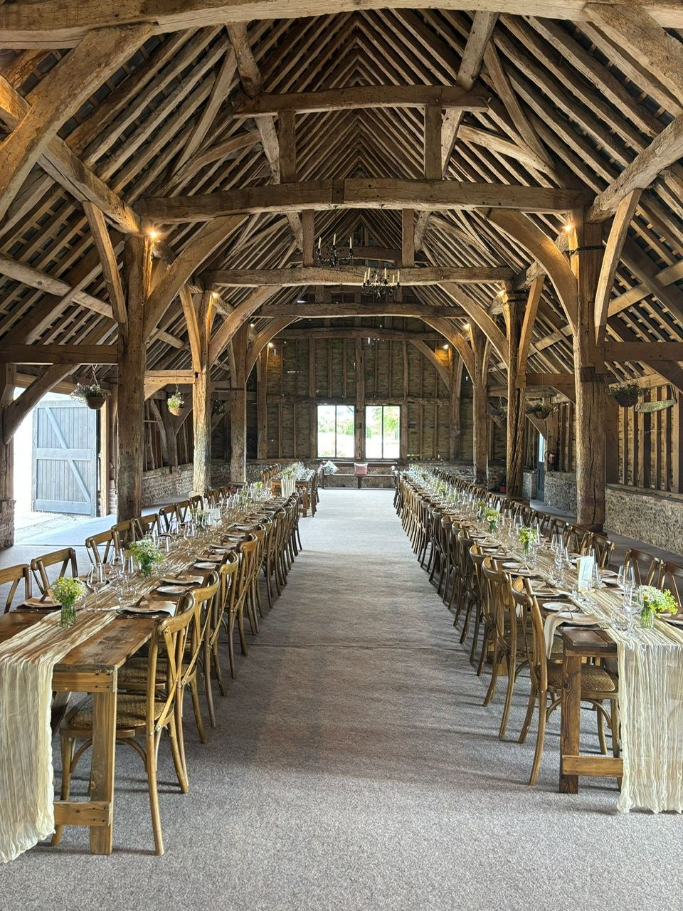 Rustic barn wedding venue at Pinglestone in Winchester, styled with long banquet tables and wooden beams
